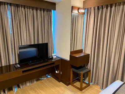 a hotel room with a desk with a television at 8 Adriatico Condo beside Robinsons Mall Y1 in Manila