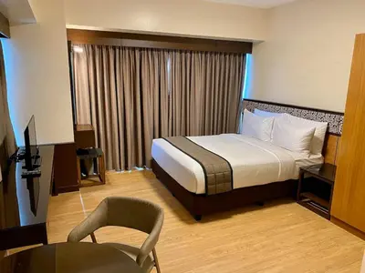 a hotel room with a bed and a desk and a chair at 8 Adriatico Condo beside Robinsons Mall Y1 in Manila