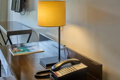 a desk with a telephone and a lamp on it at Sea View older in Manila