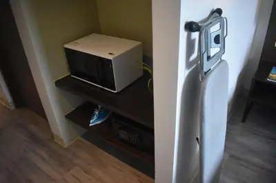 a refrigerator with a microwave sitting on a shelf at Sea View older in Manila