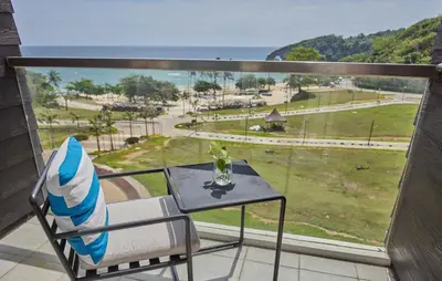 a chair and table on a balcony with a view of a park at Sea View older in Manila