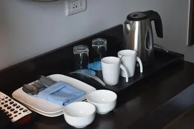 a black counter with cups and utensils on it at Sea View older in Manila