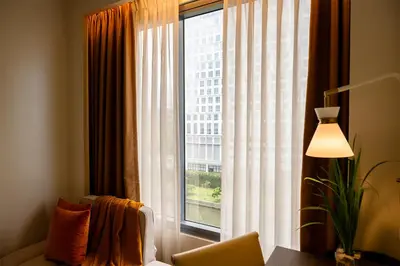 a large window with a view of a building at Modern City Stay Near Manila Bay Attractions in Manila