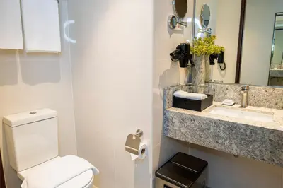 a bathroom with a toilet and a sink and a mirror at Modern City Stay Near Manila Bay Attractions in Manila