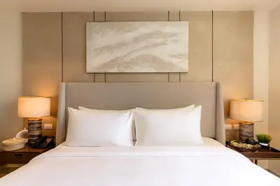 a bedroom with a bed with two lamps and a painting at Modern City Stay Near Manila Bay Attractions in Manila