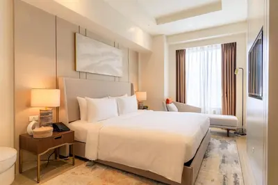 a bedroom with a large white bed and a window at Modern City Stay Near Manila Bay Attractions in Manila