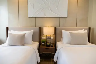 two beds in a hotel room with white pillows at Modern City Stay Near Manila Bay Attractions in Manila
