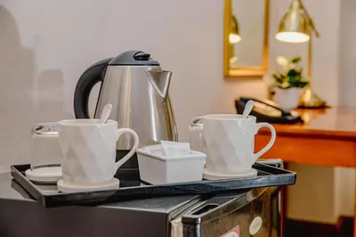 a tray with three coffee cups and a tea kettle at Ortigas CBD Near Business & Shopping Hubs in Manila