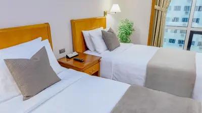 a hotel room with two beds and a window at Ortigas CBD Near Business & Shopping Hubs in Manila
