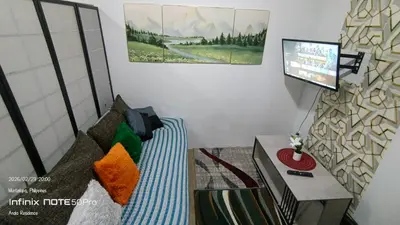 a living room with a bed and a flat screen tv at Alabang Staycation By Renz in Manila