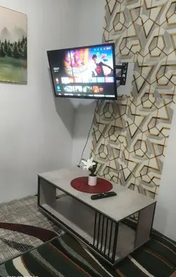 a living room with a tv on a wall at Alabang Staycation By Renz in Manila