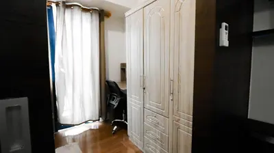 a cat is standing next to a large white cabinet at Smart Cozy Home Air Residences Makati 4125 in Manila