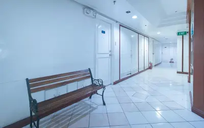 a empty hallway with a bench in a building at RedDoorz at MPT Suites in Manila
