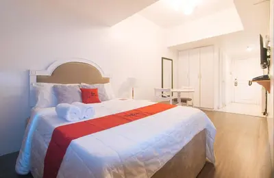 a bedroom with a large bed with towels on it at RedDoorz at MPT Suites in Manila