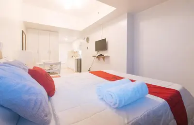 a bedroom with a bed with two towels on it at RedDoorz at MPT Suites in Manila