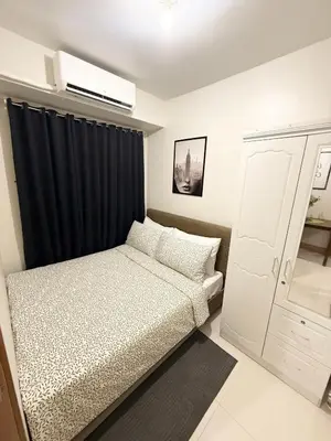 a bedroom with a bed and a black curtain at Obetskie's Haven Condotel in Manila