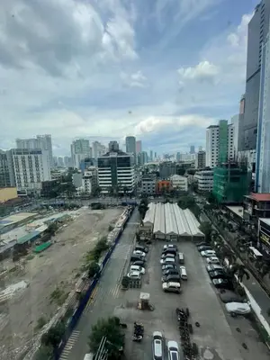 a city with cars parked in a parking lot at A Venue Residences 9133 in Manila