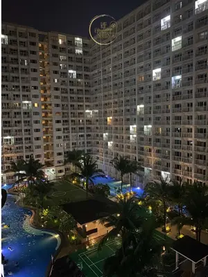 a view of a large building at night at RJE Staycation Suites Mall of Asia near Airports in Manila