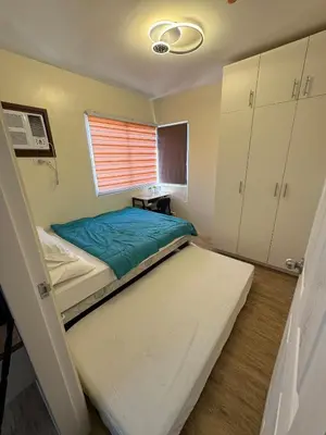 a small bedroom with a bed and a window at Berkeley Suites, Silang Cavite in Silang