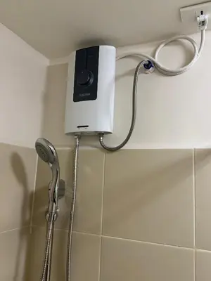 a shower with a shower head and a shower at Berkeley Suites, Silang Cavite in Silang