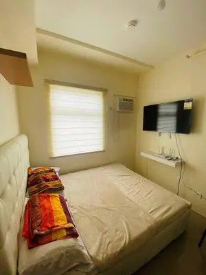 a small bedroom with a bed and a television at Fully Furnished Condo for Rent in Manila