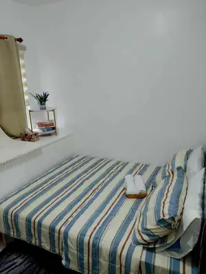 a bedroom with a bed with a striped blanket at South Residence Condo Las Pinas, Manila in Manila
