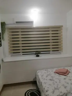 a bedroom with a bed and a window with a plant at South Residence Condo Las Pinas, Manila in Manila