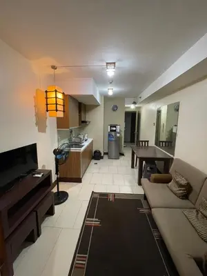 a living room with a couch and a table at Makati City Antel Spa Residences 2707 in Manila
