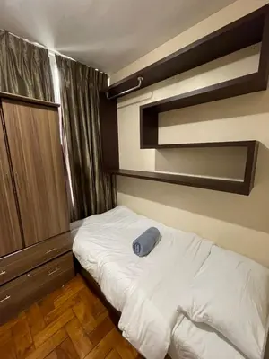 a bedroom with a bed with a blue pillow on it at Makati City Antel Spa Residences 2707 in Manila