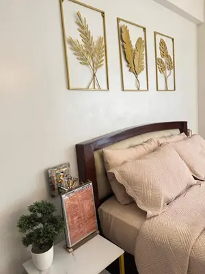 a bedroom with a bed and three pictures on the wall at Chic Unit with Balcony - Free wifi & netflix across Naia Terminal 3 Airport in Manila