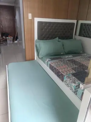 a bed with green pillows at Shell Residences in Manila