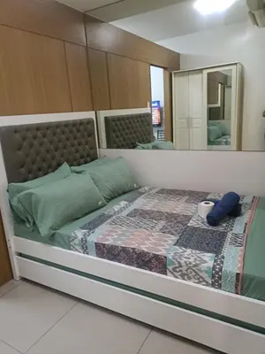 a bedroom with a large bed with a mirror at Shell Residences in Manila