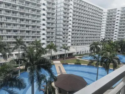 a view of a pool with palm trees and buildings at Shell Residences in Manila