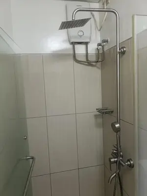 a shower with a shower head in a bathroom at Shell Residences in Manila