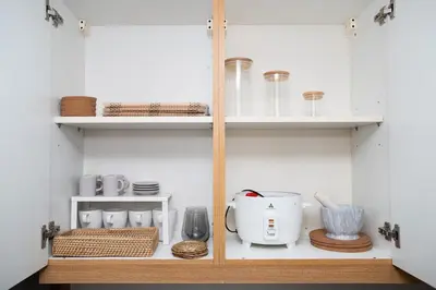 a kitchen with white cabinets and a counter with utensils at Brand New Unit Shell Residences 1BR Near MOA NAIA in Manila