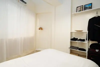 a bedroom with a white bed and a closet at Brand New Unit Shell Residences 1BR Near MOA NAIA in Manila