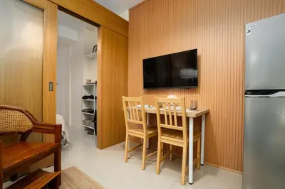 a kitchen with a table and a television on a wall at Brand New Unit Shell Residences 1BR Near MOA NAIA in Manila