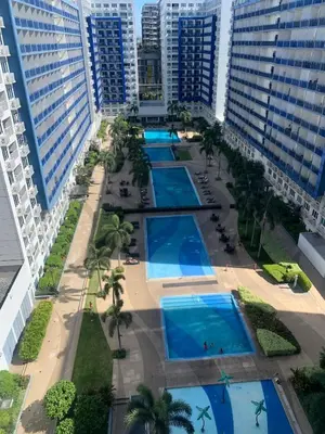 an overhead view of a pool in a resort with tall buildings at MOA Staycation - by Marites in Manila