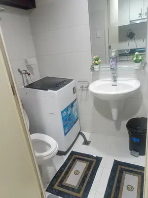 a white bathroom with a toilet and a sink at MOA Staycation - by Marites in Manila