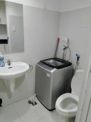 a bathroom with a toilet and a sink at MOA Staycation - by Marites in Manila