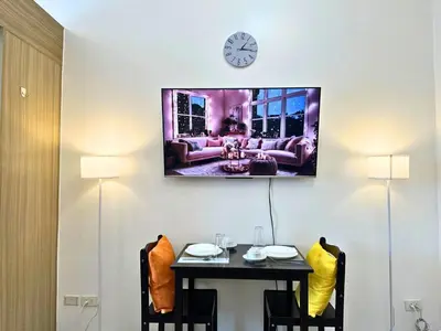 a room with a table and a clock on the wall at Cozy Luxe Stay 55 inch 4k Ultra TV and Amenity View in Manila