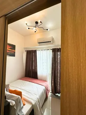 a small bedroom with a bed and a window at Cozy Luxe Stay 55 inch 4k Ultra TV and Amenity View in Manila