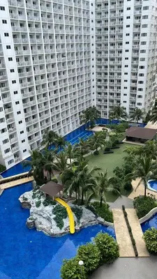 a view of a resort with palm trees and a water slide at Cozy Luxe Stay 55 inch 4k Ultra TV and Amenity View in Manila
