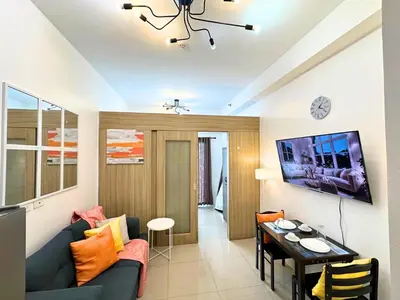 a living room with a blue couch and a table at Cozy Luxe Stay 55 inch 4k Ultra TV and Amenity View in Manila