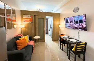 a living room with a couch and a table at Cozy Luxe Stay 55 inch 4k Ultra TV and Amenity View in Manila