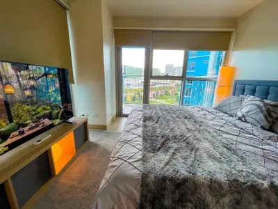 a bedroom with a large bed and a large window at Sophisticated City Escape Steps from Solaire & City of Dreams in Manila