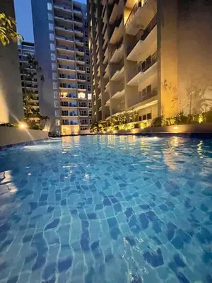 a large swimming pool in a city at night at Sophisticated City Escape Steps from Solaire & City of Dreams in Manila