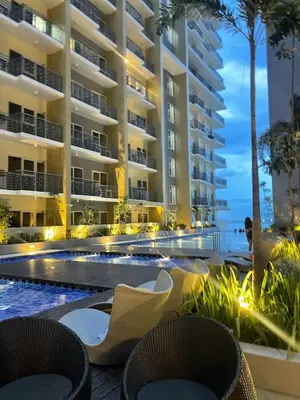a resort with a swimming pool and two chairs at Sophisticated City Escape Steps from Solaire & City of Dreams in Manila