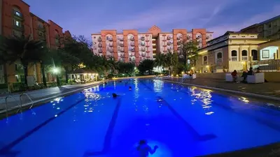 a large blue swimming pool with buildings in the background at Chateau Elysee A11 near bar resto mall Airport in Manila