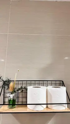 a shelf with two towels and a vase of flowers at AdahkuMaya Luxury Suites in Manila